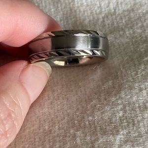 Men’s silver wedding band with rope detail on top and bottom.
